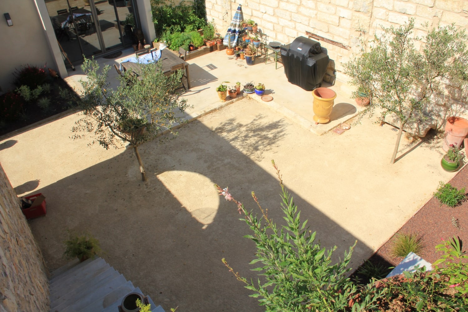 terrasse en béton lissé marius aurenti et bordures en pierre pour aménager cette cour extérieure